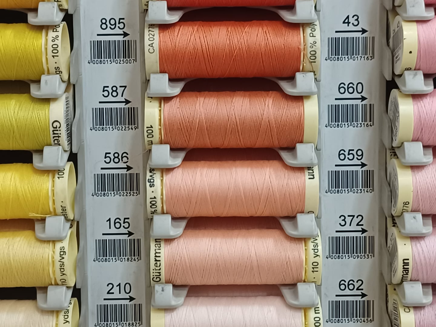 Detail crop of the original 12-megapixel HEIC photo of colorful sewing thread spools, at 100% zoom
