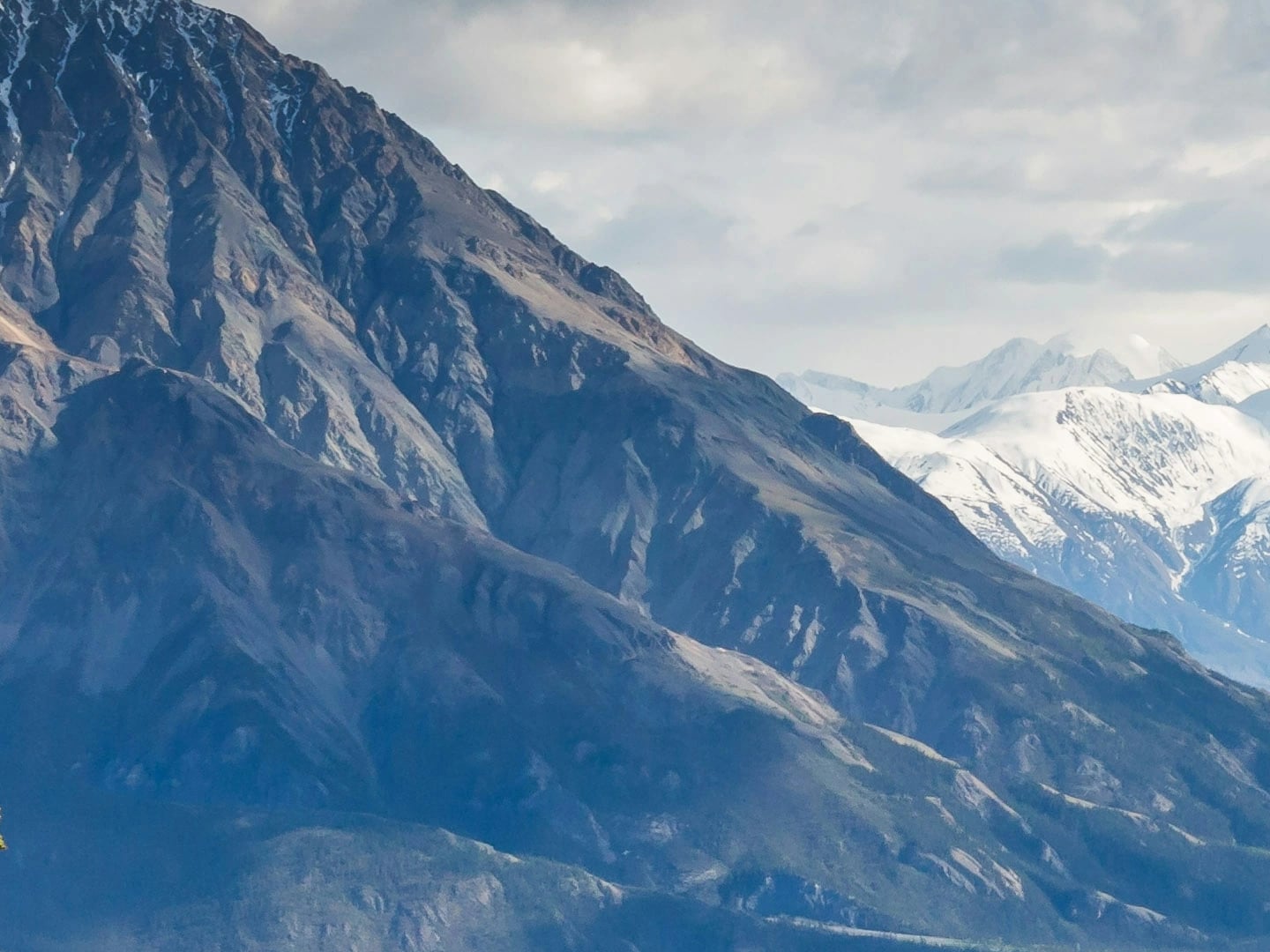 Detail crop of the original 22-megapixel WebP photo: a rugged mountain ridge before snow-capped peaks, at 100% zoom